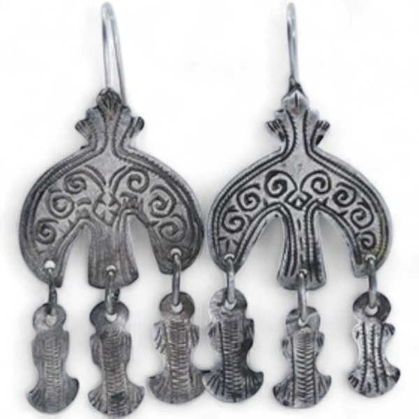 Pair of silver earrings with intricate designs on a white background